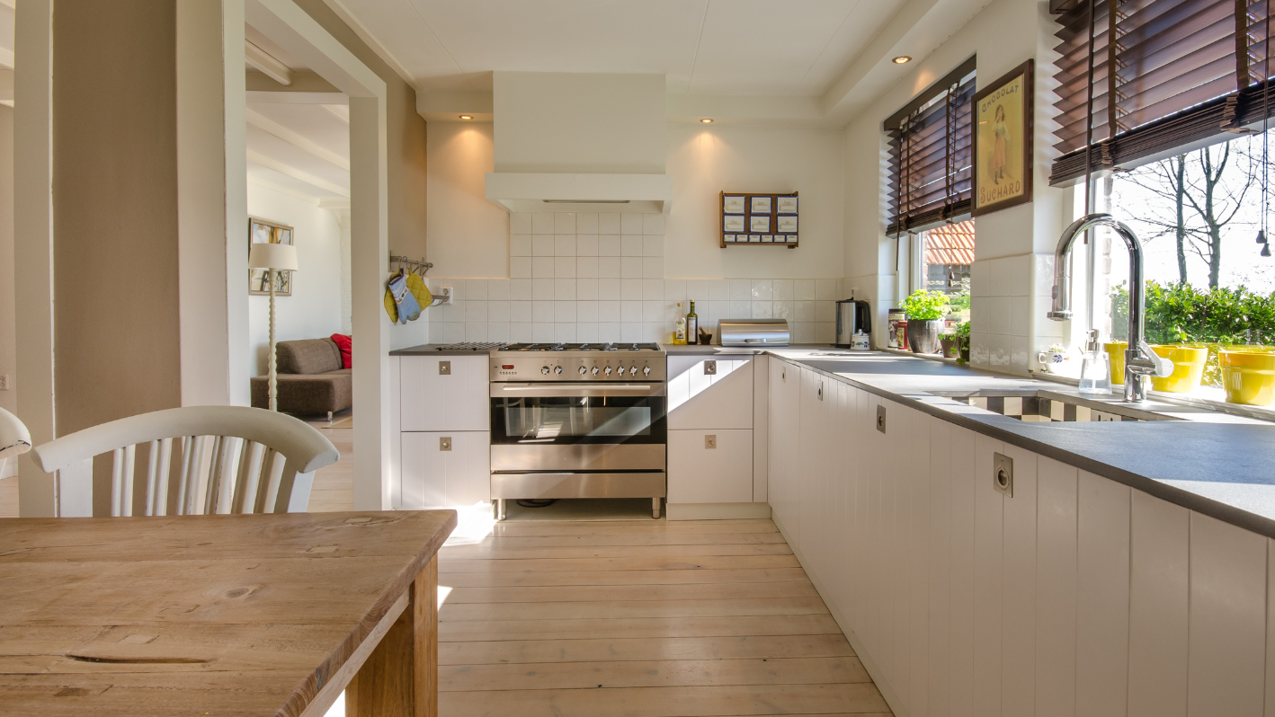 A kitchen with a wooden table and white cabinets