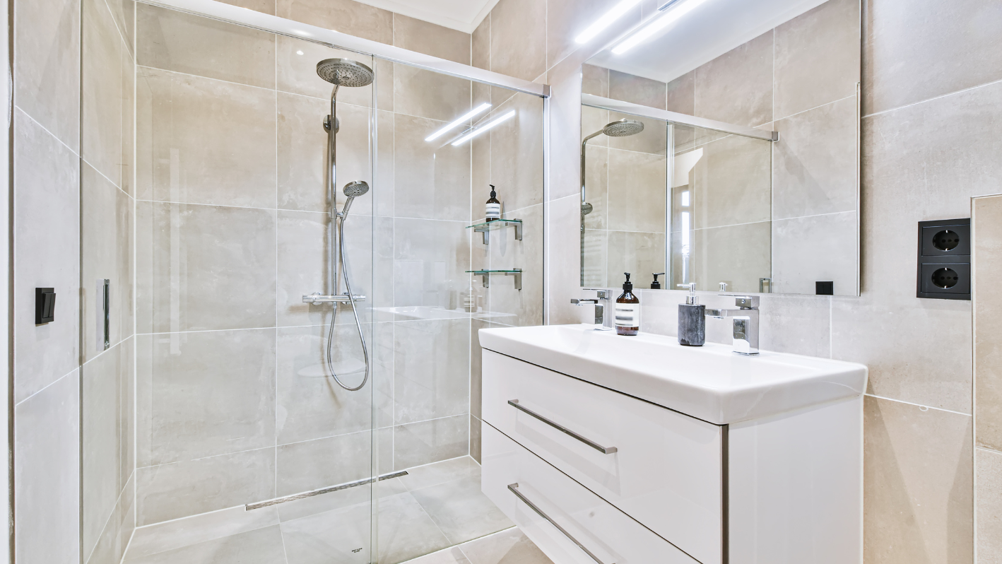 A bathroom with a walk in shower next to a sink